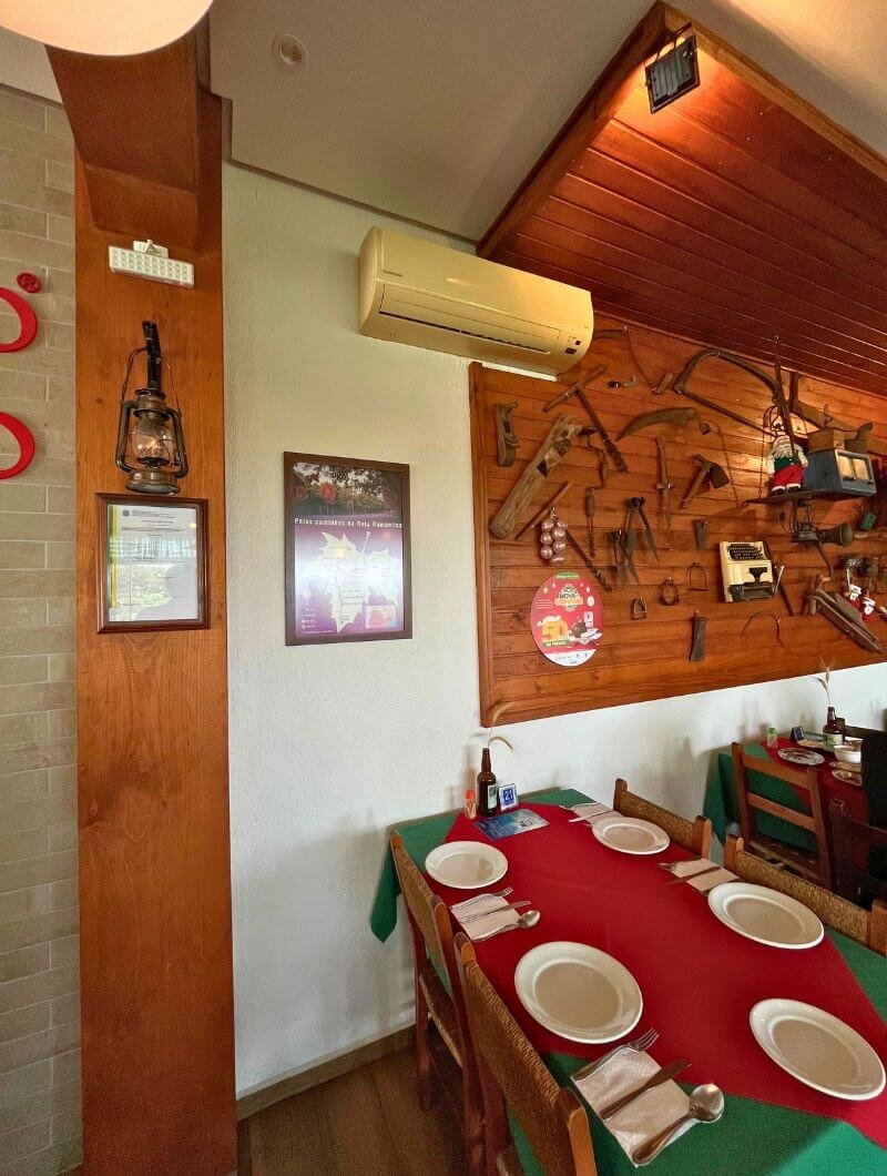 Salão aconchegante do Galeto Piccolo Pollo em Nova Petrópolis, decoração temática italiana e mesas postas para o almoço.