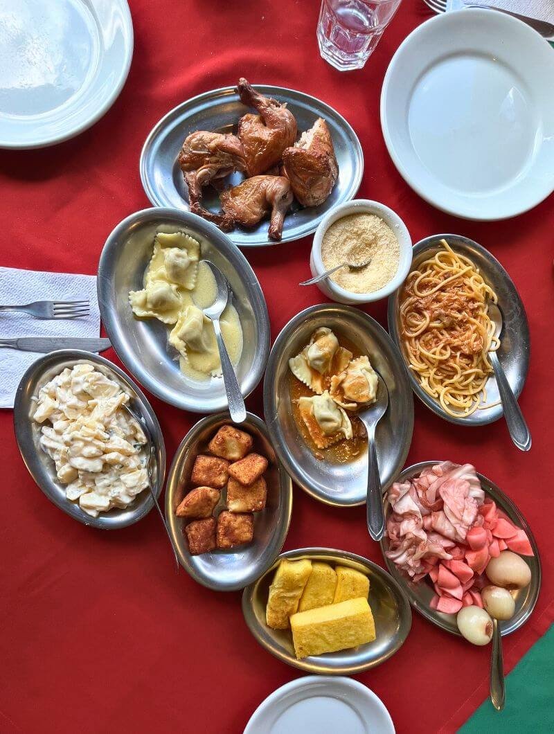 Mesa do rodízio em Nova Petrópolis – Galeto Piccolo Pollo: travessas com galeto primo canto, massas artesanais e acompanhamentos típicos da Serra Gaúcha.